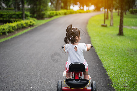 在花园里骑自行车的可爱婴儿玩具平衡后院公园童年孩子家庭情感学习微笑图片