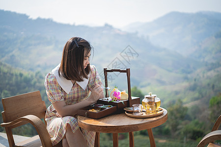 坐在椅子上 坐在山的风景上 吃着蛋糕和喝着热茶图片