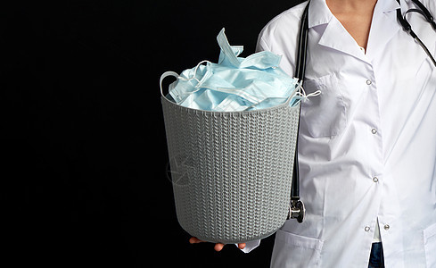 医生用桶装满了旧面罩 扔掉作为流行病结束的象征物胜利流感感染卫生药品疾病外科肺炎病人医疗图片