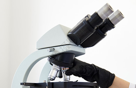 在现代实验室特写显微镜和戴橡胶手套的手 在现代实验室医生化学科学研究女士制药科学家实验技术女性图片