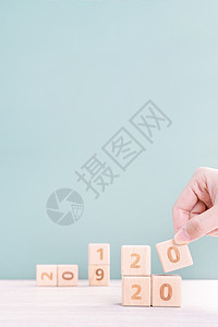 摘要 2020 2019 新年倒计时设计理念  女性在木桌和绿色背景上拿着木块立方体特写复制空间桌子日历女士金融创造力灰色商业成图片