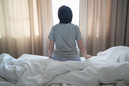 背对着女人的眼神 感到沮丧和坐在床上情感房子挫折女性悲伤女士孤独者房间女孩失败图片