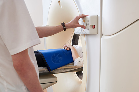 妇女通过计算机化轴心扫瞄器进行X光CAT扫描仪 医生操作MRI设备图片