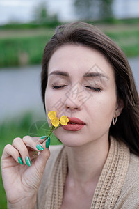 美丽的棕发女人的肖像 黄色的小野花 皮肤护理 自然香味花束享受女士香水呼吸手指女性头发图片