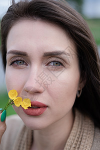 美丽的棕发女人的肖像 黄色的小野花 皮肤护理 自然呼吸女性手指头发花束女士香水香味享受图片