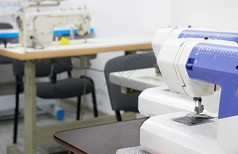在餐饮室或裁缝车间缝纫机作坊制造业纺织品设计师剪裁包缝女裁缝针线活工厂职业图片