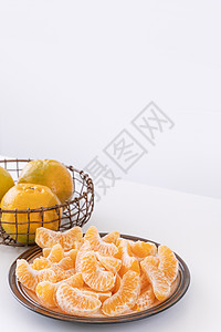 盘子里漂亮的去皮橘子和金属篮子 在现代现代厨房岛的明亮白色干净桌子上隔开橙子果汁食物摄影水果服务月球热带图片