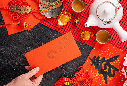 中国农历一月新年的设计理念女人拿着 给红包 红包 红包 作为幸运钱 顶视图 平躺 头顶上方 春字的意思是春天来了杯子硬币桌子庆典图片