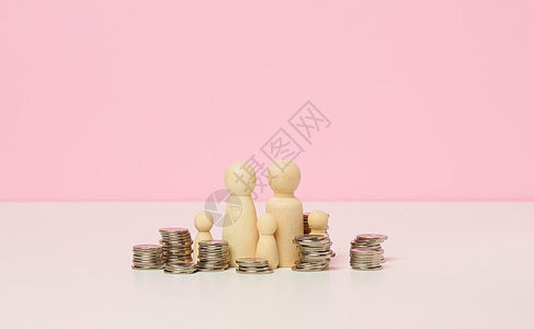 白桌上男子的金属硬币和木偶 储蓄和开支 家庭预算 补贴等费用图片
