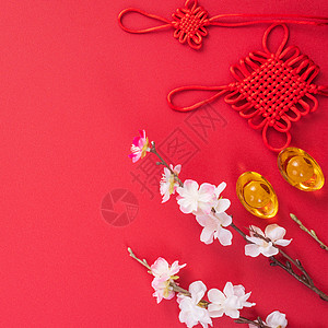 中国农历新年的设计理念美丽的中国结与梅花隔离在红色背景 平躺 顶视图 头顶布局桌子文化庆典金子工艺艺术传统节日边界高架图片