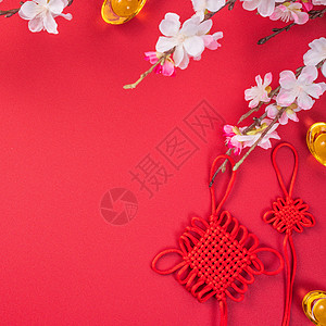 中国农历新年的设计理念美丽的中国结与梅花隔离在红色背景 平躺 顶视图 头顶布局文化月球金子桌子平铺庆典节日艺术工艺假期图片