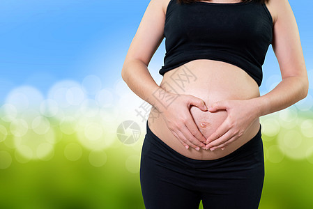 孕妇将双手握在腹部的心脏形状中婴儿肚子怀孕卫生产妇保健送货母性妇科家庭图片