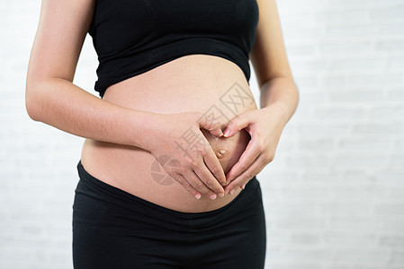 孕妇将双手握在腹部的心脏形状中送货母亲生长生育力卫生女性妇科家庭孩子母性图片