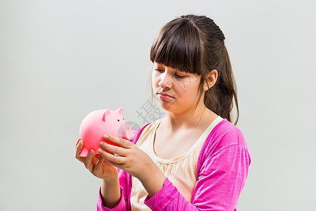 抱着小猪银行的可怜小女孩背景悲伤童年财富货币年龄愤怒投资小学灰色图片