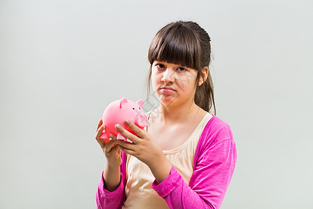 抱着小猪银行的可怜小女孩童年愤怒小姑娘小学灰色钱盒女性投资金融年龄图片
