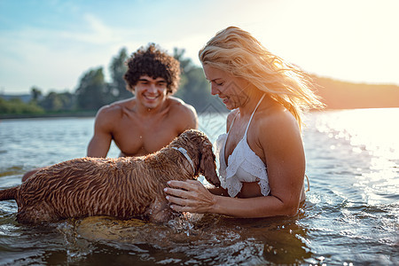 享受夏日快乐动物幸福焦点友谊女士海滩男人宠物微笑水平图片