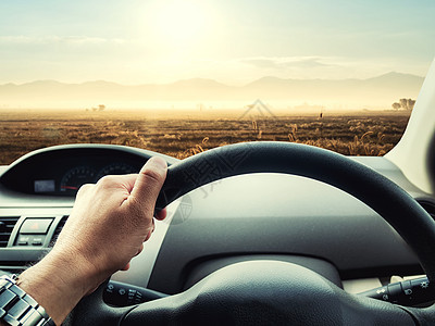 男子驾驶的汽车在路上男性太阳日出沥青控制板旅行镜子运输天空自由图片