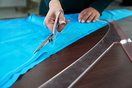 在裁缝制衣室 餐饮店 切割蓝布的服装师女士工艺粉笔工作室设计师针线活剪刀织物剪裁材料图片
