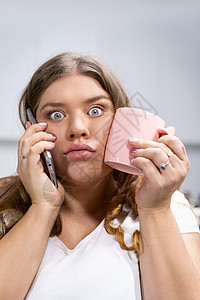 超重的年轻女性在电话上交谈 与冷水触摸小鸡一起举杯 在手机上说话的时髦胖胖女学生潮湿无比 体弱不堪图片