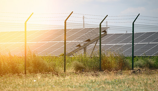 阳光明媚的一天 在田地中间的太阳能电池板上 乌克兰力量技术细胞蓝色场地绿色发电机活力太阳栅栏图片