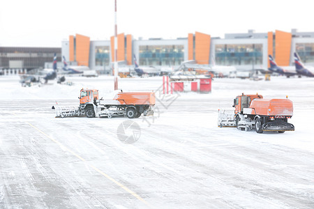 在雪暴期间 从跑道和机场的路上抽下雪雪花 通过窗口观看飞机场车辆风暴降雪卡车飞机航空客机服务驾驶图片