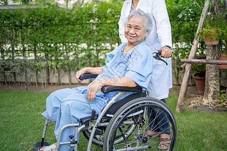 医生帮助和照顾坐在护理医院病房公园轮椅上的亚洲老年或老年老妇人患者 健康强大的医疗理念挑战疾病护理幸福女性女士病人男人退休车轮图片