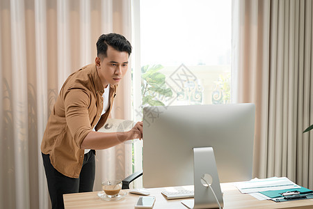 一个严肃的亚洲商务人士思维和集中打在工作场地上的Pc的肖像 共同办公空间办公室职场男人业者工人技术桌子商业商务电脑图片