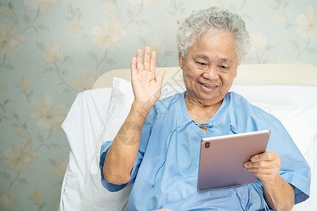 亚洲年长或老年老年妇女使用数字平板电脑进行视频通话;社会偏移概念 18图片