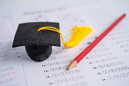 毕业差距帽和铅笔在答题表背景上 教育研究测试学习教学概念中写作调查问卷考试测验控制床单帽子学校学生解决方案图片