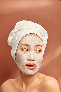 她脸上戴着粘土面罩 头部戴着毛巾微笑 照片来自Flickr用户Twitter网站温泉润肤面具奶油化妆品治疗女士身体皮肤护理背景图片