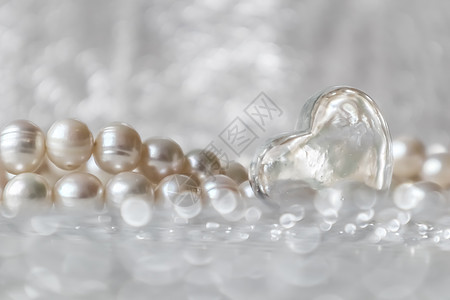 天然的白珍珠珠珠和闪闪发亮背景的透明心脏背景图片