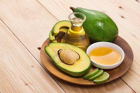 健康食品概念 新鲜有机鳄梨油 配有蜂蜜水果保健食物身体洗澡木头治疗瓶子液体桌子图片