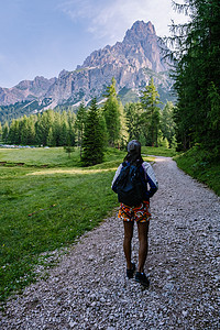 在意大利多洛米蒂山脉徒步旅行的女人 在意大利多洛米蒂山脉徒步前往的女孩 意大利高山旅游顶峰游客女性冒险山脉山地远足头盔图片