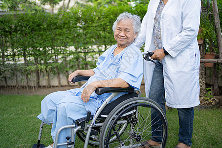 医生帮助和照顾坐在护理医院病房公园轮椅上的亚洲老年或老年老妇人患者 健康强大的医疗理念退休护理微笑椅子疾病摩托车机动性幸福女性男图片