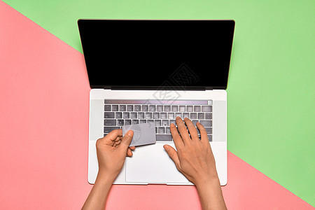 使用手提笔记本电脑键盘上的信用卡用空白屏幕监视器进行手工购物的人图片