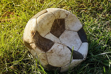 草坪上撕裂的足球 足球皮在场上撕裂但仍在比赛中使用图片