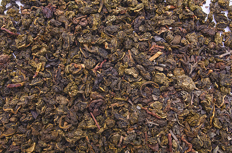 在白色背景和特写镜头的牛奶乌龙茶 作为背景的干乌龙茶叶子 从上面射出的发酵中国茶图片