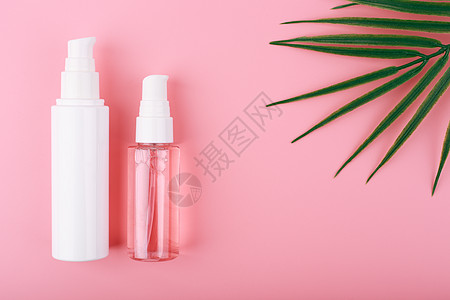 平铺在粉红背景 棕榈叶和复制空间的一套美容产品上图片