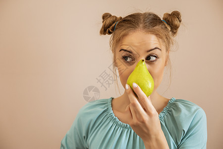 持有梨子的妇女卫生意识茶点健康饮食水果护理重量金发女郎活力生活方式图片