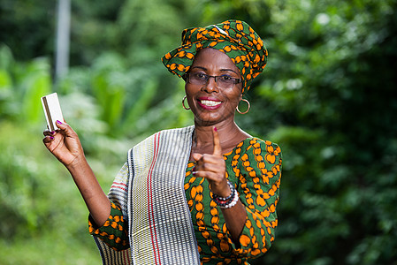 非洲服饰在自然背景上出示信用卡的非洲妇女肖像照片 Name工作室银行业债务投资薪水旅行女士现金购物旅游背景