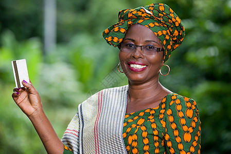 在自然背景上出示信用卡的非洲妇女肖像照片 Name成功旅游投资卡片服饰收益快乐现金薪水租户图片