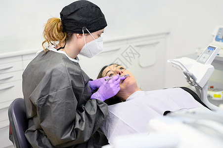 年轻牙医在现代医院为女病人工作 他们向妇科医生提供治疗医生微笑保健职业矫正牙科女性访问牙齿女士图片