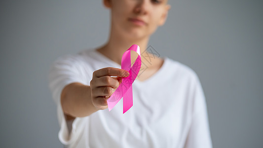 身穿白色T恤的无脸妇女带着粉色丝带 作为白背景乳腺癌的象征 笑声胸部幸存者保健帮助手术女性机构治愈预防全世界图片