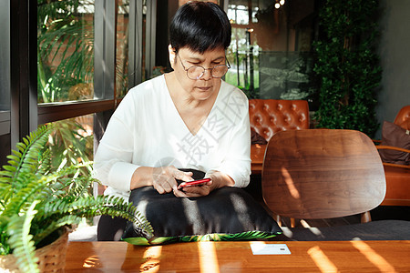 网络周一销售概念 高龄女性为网上购买智能手机付费金融互联网商业世界价格零售店铺假期顾客通讯图片