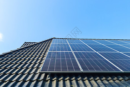 太阳能电池板在有黑色屋顶砖的住宅房顶顶上生产清洁能源集电极活力回收阳光生态控制板家庭创新技术花园图片