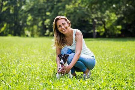女人和她的狗杰克罗素泰瑞 在大自然中度过时间忠诚幸福动物哺乳动物活动享受阳光喜悦犬类休闲图片