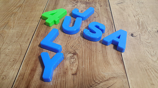 美国4July USA字的塑料彩色字母表被放在木地板上图片
