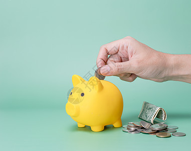 手工在小猪银行存钱帐户基金退休小猪储蓄安全存钱罐硬币经济商业图片
