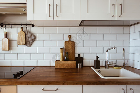 厨房的铜器 厨具附件 用白瓷砖墙挂起厨房的壁板和木板家具烤箱器具房子植物财产住宅风格房间窗户图片