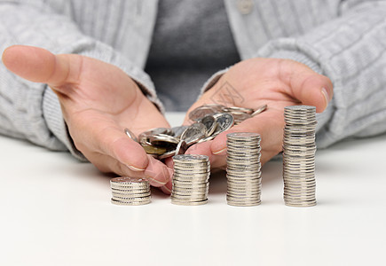 一堆白色硬币和女性手拿着一堆硬币 贫困 预算规划 补贴低薪图片